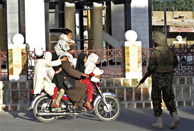 An Afghan security personnel checks a bike with seven passengers after gunmen launched an attack on the compound of the governor of Kandahar province  in Kandahar, south of Kabul, Afghanistan on Saturday, May 7, 2011.  (AP Photo/Allauddin Khan)